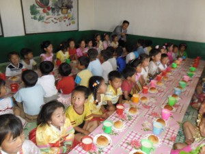 North Korean children are eating bread from a bread factory made from donations raised from the Miracle of 1000 Won.
