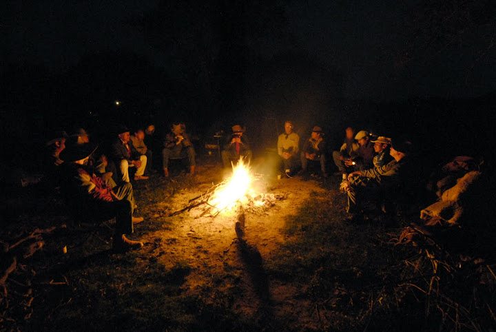 Dr. Moon and fellow cowboys sit around the fire during a cattle drive in 2008 across the Chaco region of Paraguay.